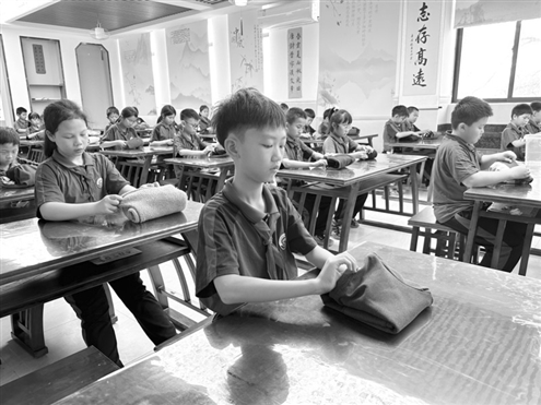 广州市增城区增江小学劳动课堂上,孩子们学习叠衣服 新华社发